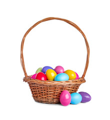 Wicker basket with bright painted Easter eggs on white background