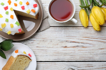 Flat lay composition with Easter cake on white wooden table. Space for text