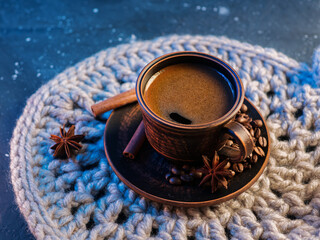 Clay espresso coffee cup, Turkish coffee, close-up on a knitted napkin, blue colored light background