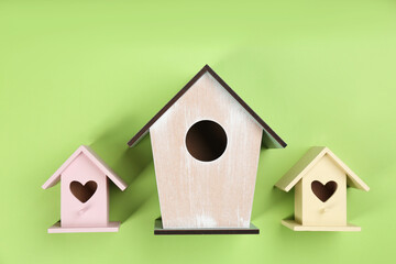 Obraz na płótnie Canvas Collection of handmade bird houses on green background, flat lay