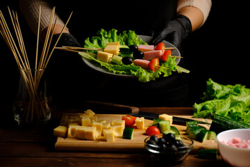 canapes of cheese, olives, cucumbers, tomatoes on lettuce leaves