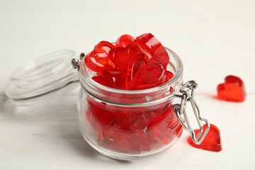 Sweet heart shaped jelly candies on white wooden table, closeup
