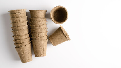 A stack of pots of peat for growing plants at home. The concept of a vegetable garden on the...