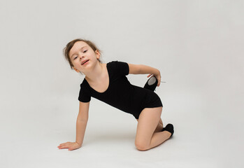 Fototapeta na wymiar fun little gymnast girl does a warm-up on a white background with a place for text