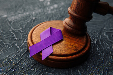 Violet ribbon and gavel on grey background - Concept of Domestic Violence law.