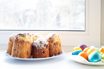 Colorful homemade painted eggs and Easter cakes on the windowsill, real life. Celebrating a great holy day