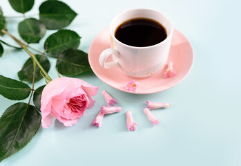 Coffee and a rose on a soft blue background. Flat lay, top view. Concept of valentines day, birthday, easter, holiday, mothers day