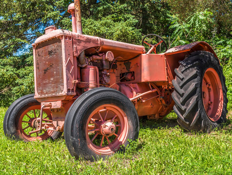 An old tractor in a field on a sunny day.