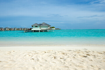 Beautiful tropical Maldives island with beach. Sea with water bungalows