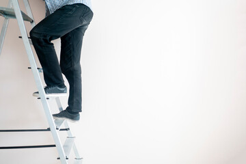 close up workers feet on the ladder climb to the top against the wall with copy space © Mihail