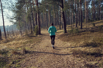 Młoda kobieta w zimny dzień biega po lesie