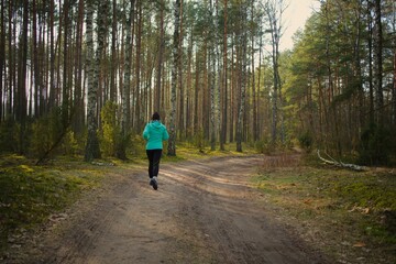 Młoda kobieta w zimny dzień biega po lesie