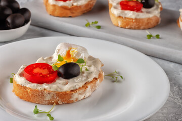 Fototapeta na wymiar Bruschetta with tomato, olives and poached quail egg