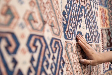 Tourist woman chooses Turkish rug at the bazaar.Traditional turkish rug shop.