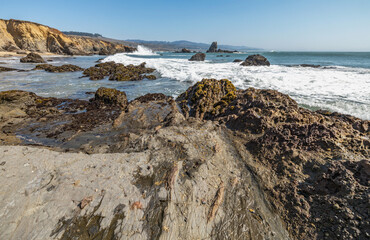Beautiful seascape of the Pacific coast in California, waves, rocks, sky, sun. Concept, perfect postcard and guide.