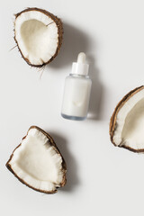 Beauty and cosmetic concept with serum bottles and coconut on white background