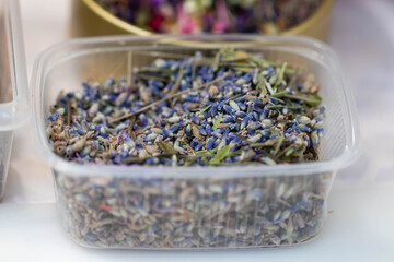 The buds of dried blue lavender flowers lie in a plastic box. Aromatherapy.