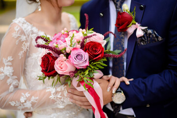 The bride and groom embrace and hold a bouquet