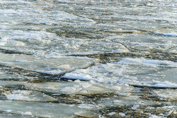 Close-up ice floes floating on the river at the end of winter on a clear sunny day.