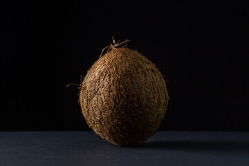 Isolated coconut on a black background. One coconut on a dark background. Healthy fruit