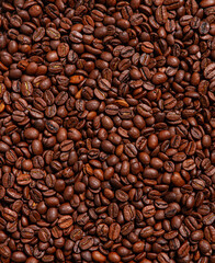 Background of roasted brown coffee beans, whole grains for making drinks, contains caffeine. Stylish textured wallpaper