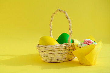 Eggs in white wicker basket and pussy willow branches, Quail eggs, easter cake on yellow background...