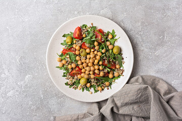 Healthy vegetarian salad with cooked chickpeas, chia seeds, fresh arugula, cherry tomatoes and olives