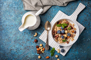 Healthy breakfast of oatmeal with milk, berry, nuts and mint