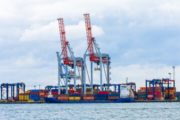 Odessa, UKRAINE - MART 1, 2021. Port cranes are loading at the Odessa port. Cranes at the port of Odessa load containers onto a commercial container ship.