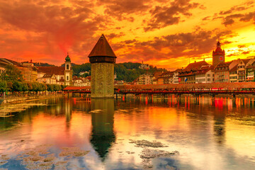 Naklejka na ściany i meble Switzerland Water Tower of Lucerne at sunset reflected in Lucerne Reuss river. Historic Chapel Bridge, famous tourist landmark of Lake Lucerne at dawn with Mount Pilatus mountain overlooking the city.