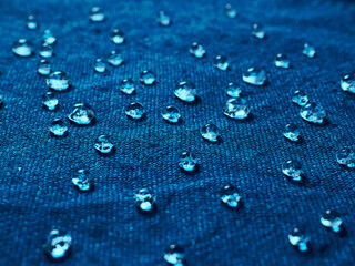 Water drops on blue waterproof fabric.