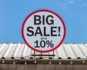A Circle billboard with text shows BIG SALE is installed on a roof. Offer of promotion sales and discount for customers.