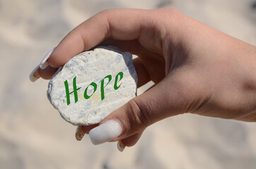 hand holding a card with the written message "Hope"