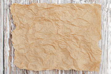 Grunge background with crumpled brown paper on a light wood background