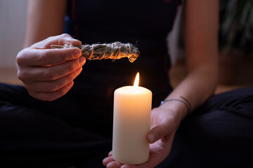 Preparation for practicing yoga at home.Burning the white sage to clean the energy of the house © yasin