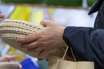 Female hands hold a knitted or wicker basket. Close-up.