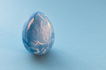 Easter blue egg on a blue background with space for text. Banner, greeting card, layout.