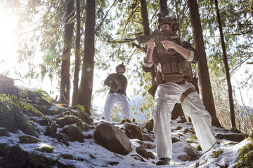 Army Man wearing Tactical Uniform and holding Machine gun in the Outdoor Rain Forest. Winter Warfare. Taken in British Columbia, Canada.