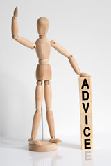 The wooden man raised his hand, and under his left hand he has cubes with the inscription - ADVICE