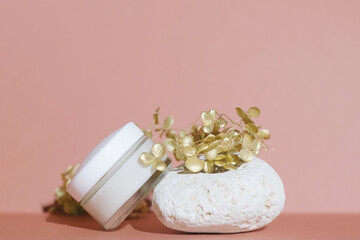 Fototapeta na wymiar Cosmetics container mockup. White moisturizing cream jar and on trendy pink background. Natural organic cosmetics concept.