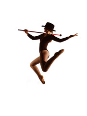 A young female dancer is seen on stage in 
front of a white background. She jumps up 
in mid air...
