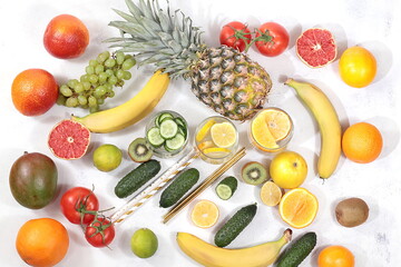 Detox diet and weight loss concept. Fruit drink and ingredients, summer tropical fruits and cocktails on a bright table, top view, healthy and natural food, source of vitamin C,