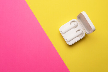 Wireless headphones on a pink background . Bright background. White headphones. Bluetooth headset. Pink and yellow background. Copy space. Modern technologies.
