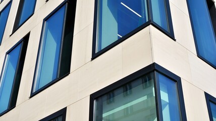 A fragment of the glass and sandstone facade of a modern office building. Wide abstract fragment of modern building facade. View of modern glass and stone facade.