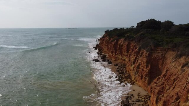 Waves crashing on a cliff with deserted beach