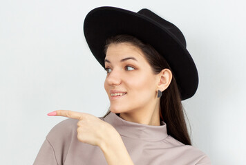 Happy surprised young female smiling broadly at camera, pointing fingers away, showing something...