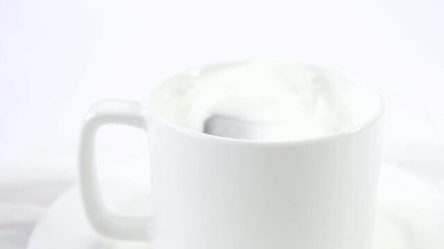 Slow motion of Cookie falling into a cup of milk