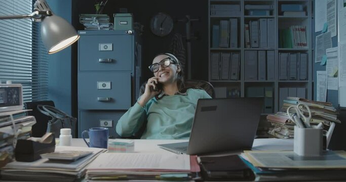 Happy office worker having a phone call in the office