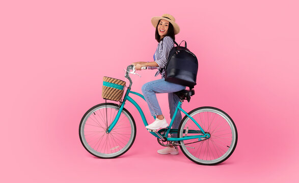 Asian Lady Riding Retro Bicycle With Wicker Basket