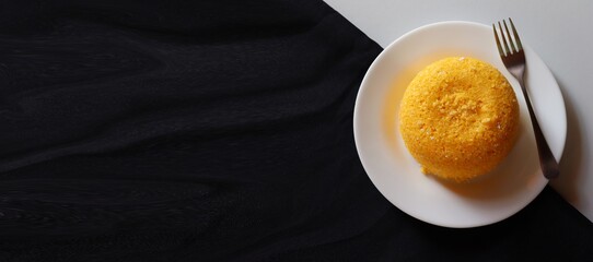 Brazilian Couscous on black background, with place for text. Typical food from the Northeast region of Brazil. Corn food.